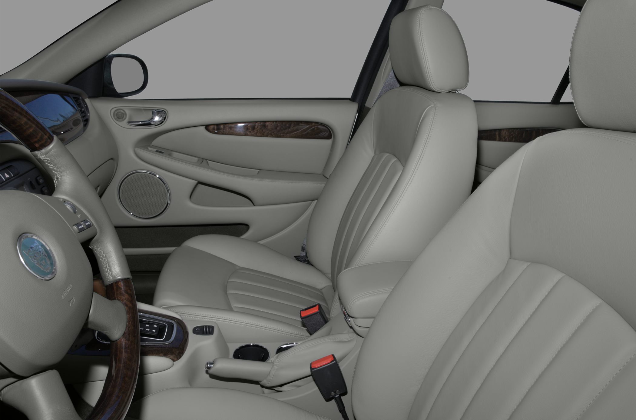 Beige leather car interior with wood trim and steering wheel