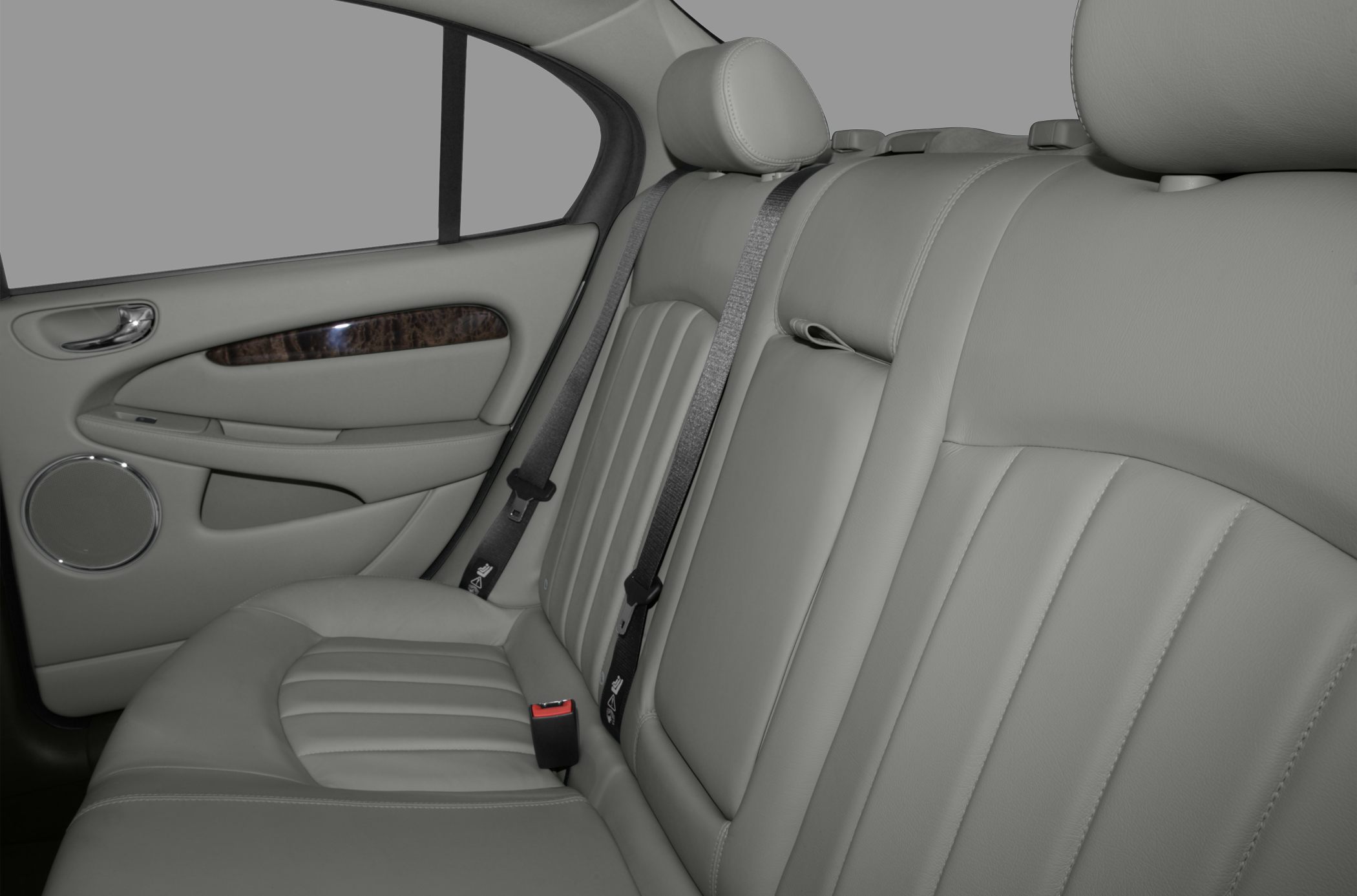 Rear leather seats with headrests, wood trim, and safety belts