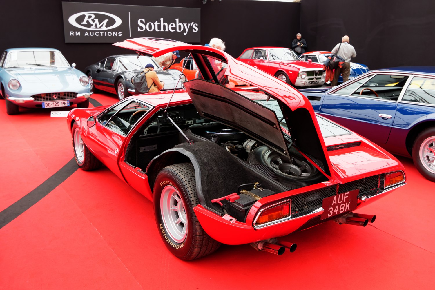 Mid-engine sports car with rear hatch open and wide rear tires