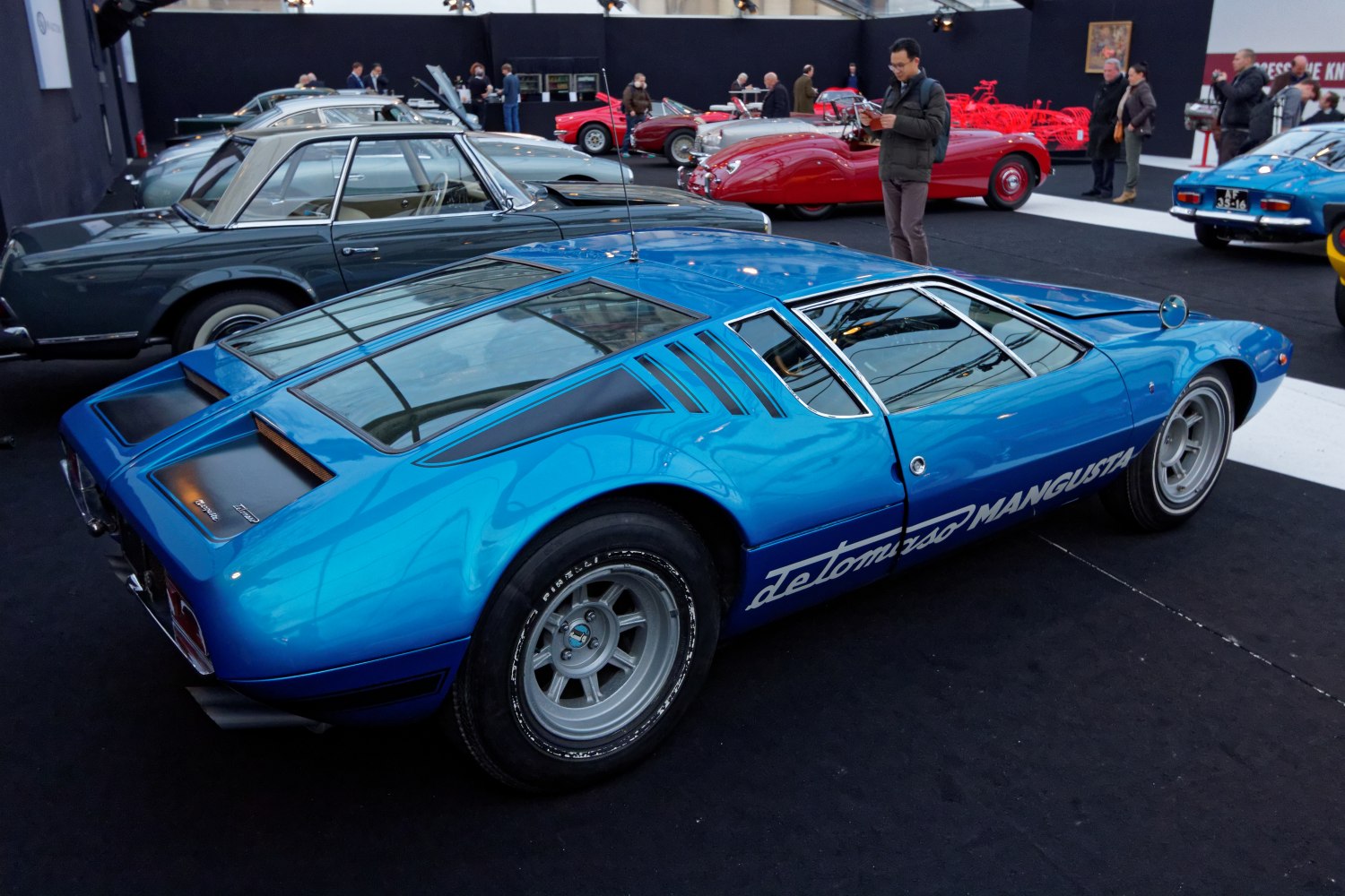 Mid-engine sports coupe with rear louvers and distinctive side vents in blue.