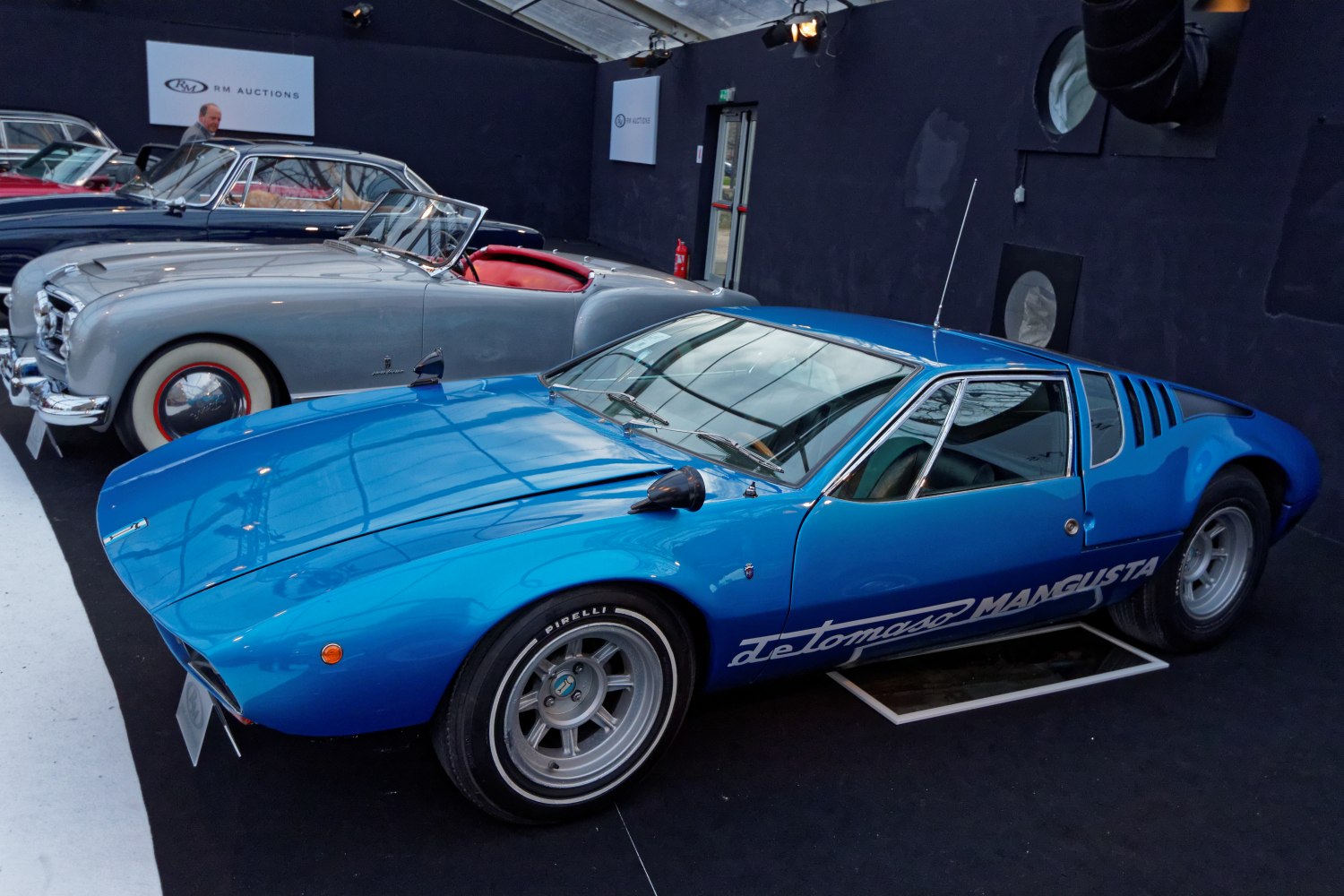 Vintage blue sports coupe with side vents and racing wheels
