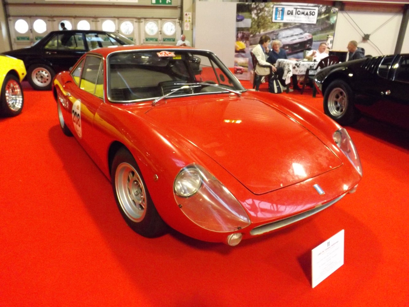 Vintage red sports coupe with sleek aerodynamic headlight covers.