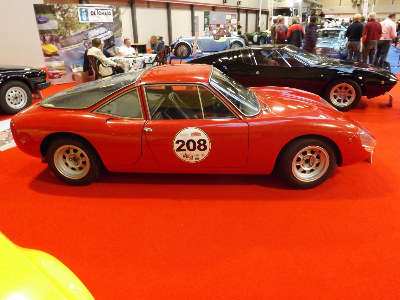 Vintage mid-engine sports coupe with racing number 208 and aerodynamic shape.