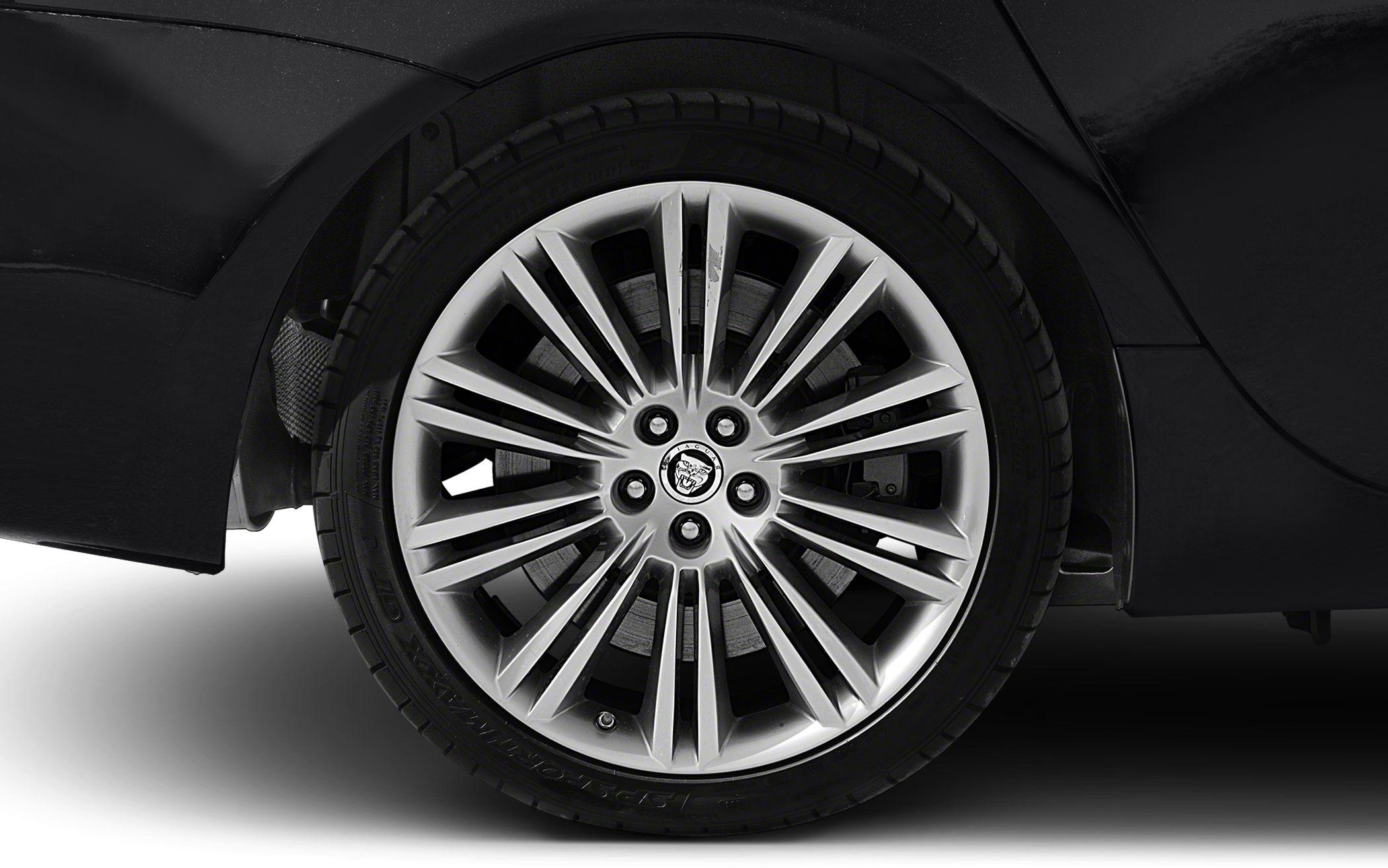 Multi-spoke alloy wheel with Dunlop tire on dark vehicle