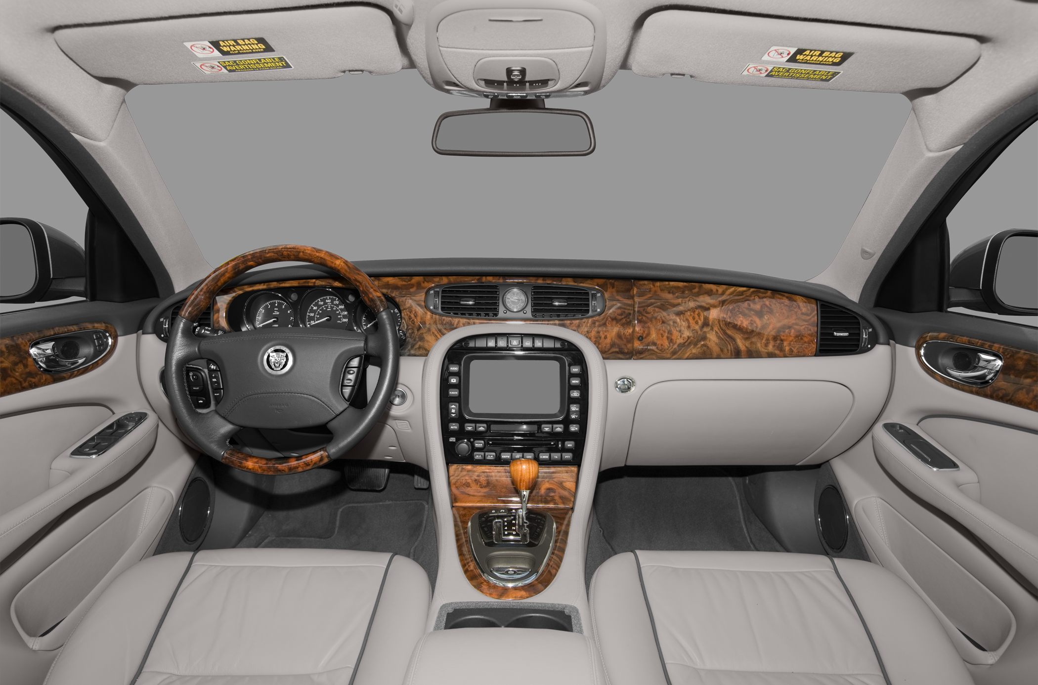 Luxury car interior with wood trim, leather seats, and advanced dashboard.