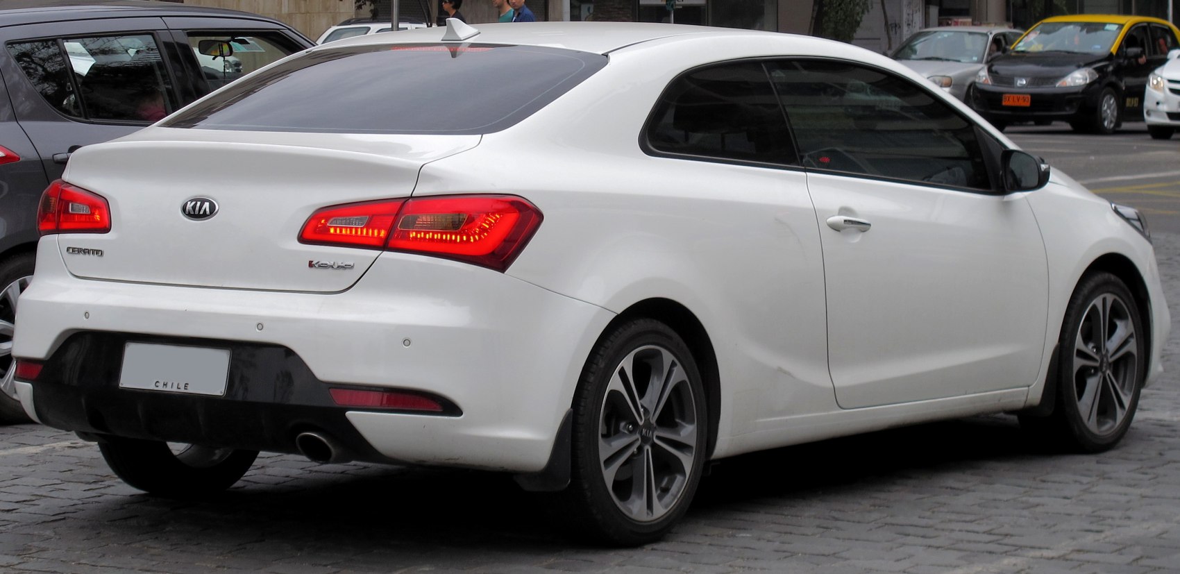 Rear and side view of white sporty coupe with distinct taillights and alloy wheels