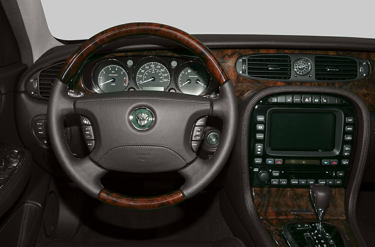 Wood-trimmed steering wheel and detailed dashboard with controls
