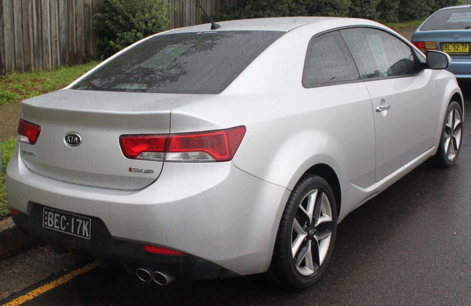 Rear side view of sporty coupe with dual exhaust and alloy wheels