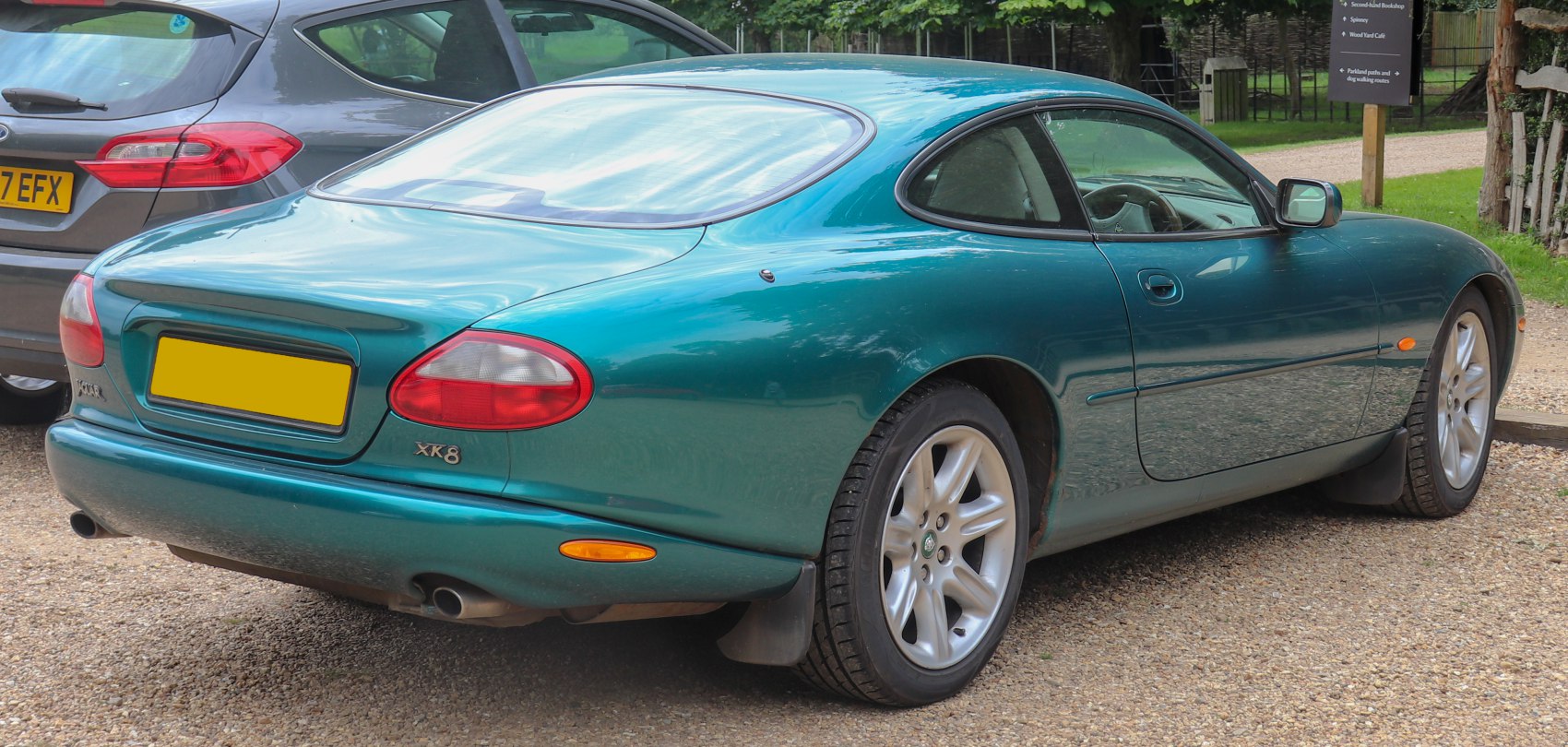 Rear and side view of sleek coupe, distinctive taillights, dual exhausts