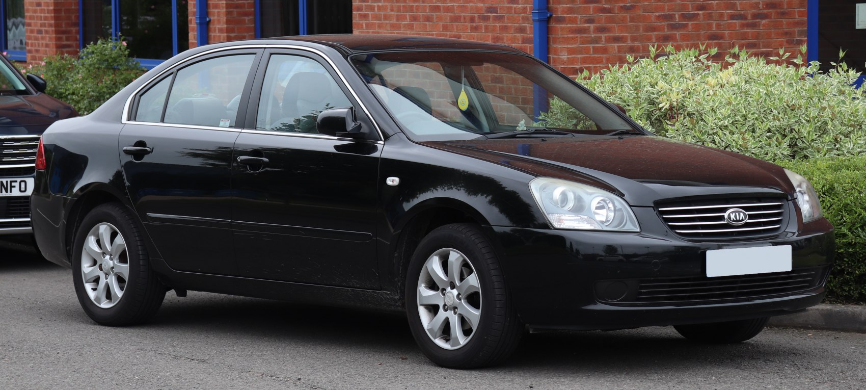 Black sedan front-side view with alloy wheels and clear headlight design