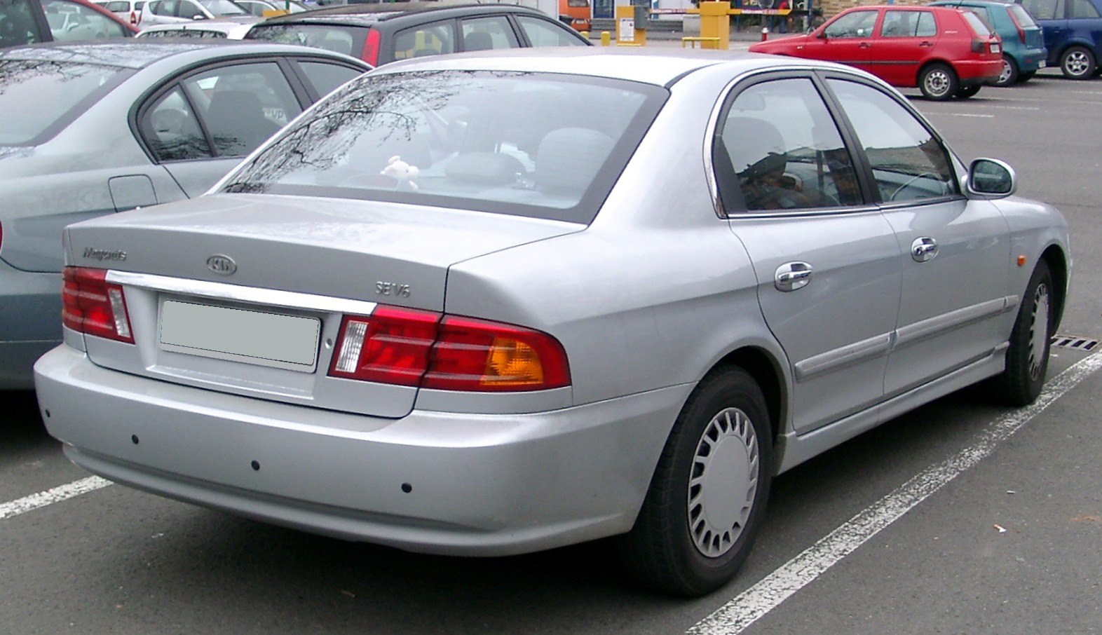 Silver sedan rear view with parking sensors and distinctive rear lights