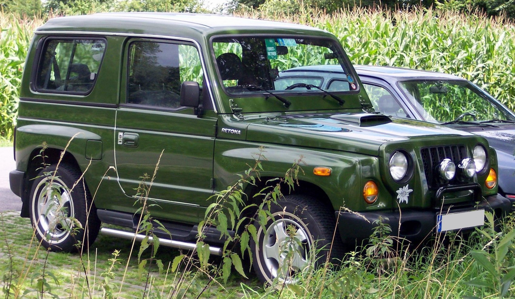SUV with round headlights, fog lights, hood scoop, and side running boards in green color