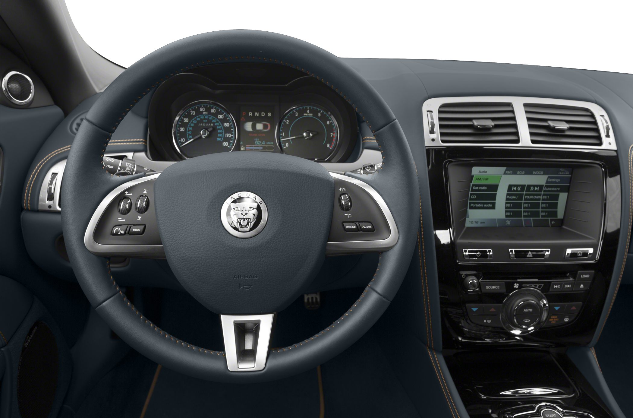 Steering wheel and dashboard of a luxury coupe with gauges and infotainment display.