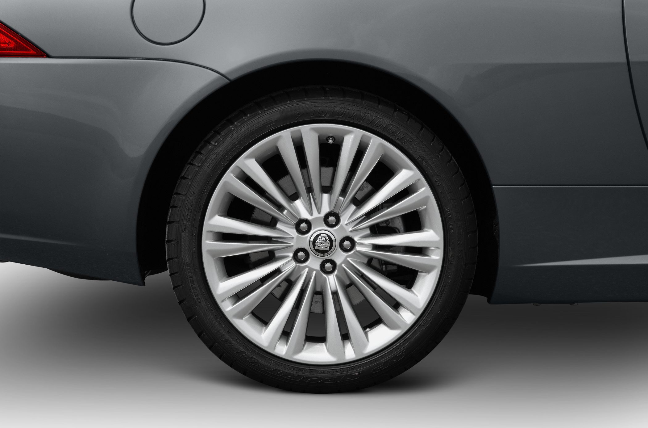 Silver multi-spoke alloy wheel with Dunlop tire on rear fender