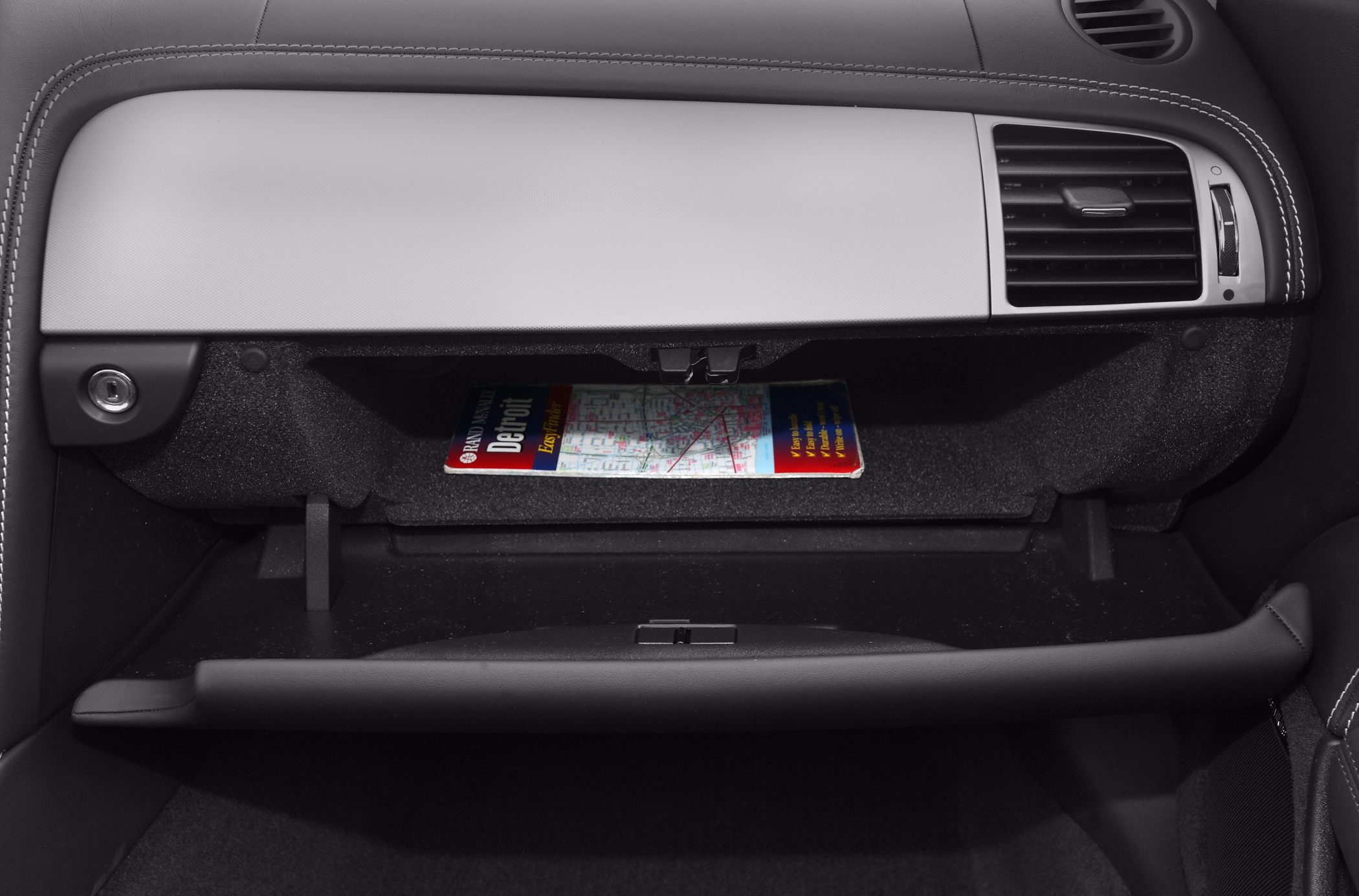 Open glove compartment with map inside and air vent detail