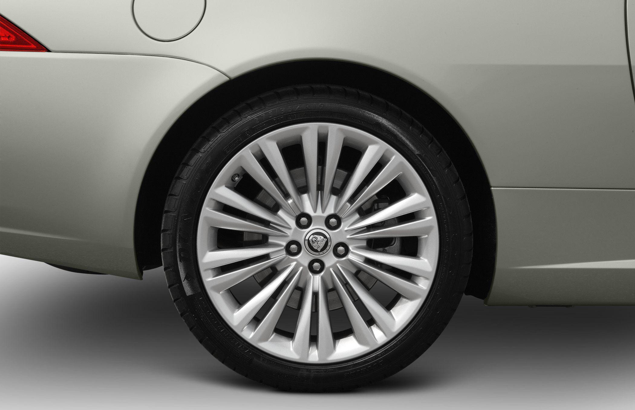 Close-up of a multi-spoke silver alloy wheel and rear quarter panel section.