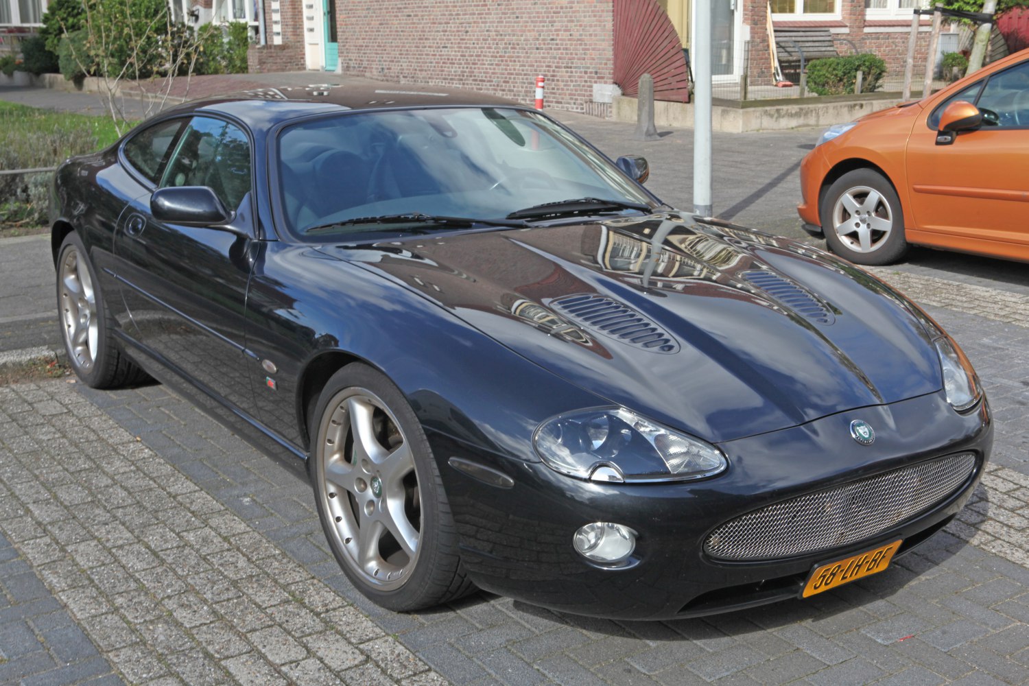 Front-side view with vented bonnet and aerodynamic coupe design