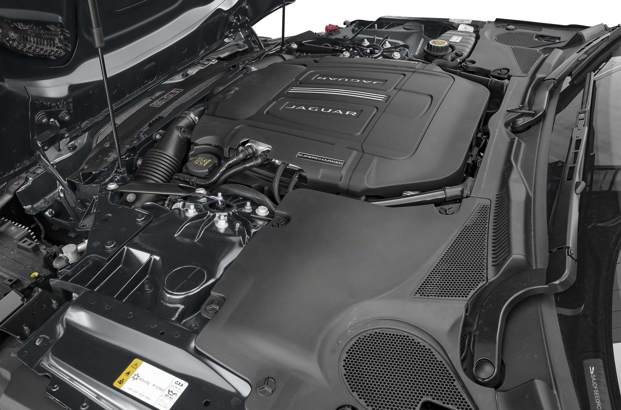 Supercharged engine bay with Jaguar branding and detailed components.