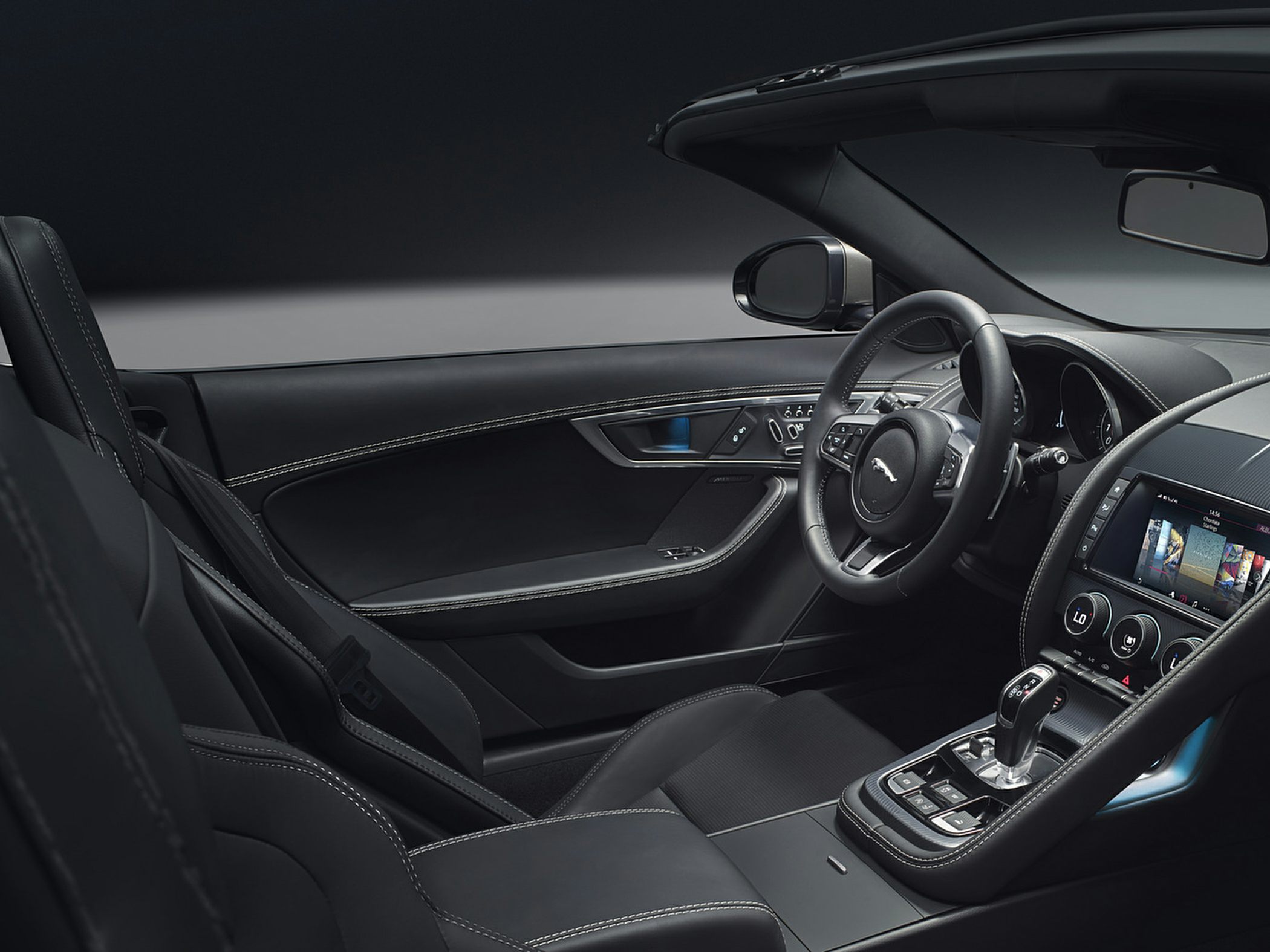 Luxury convertible interior with sporty steering wheel and infotainment screen