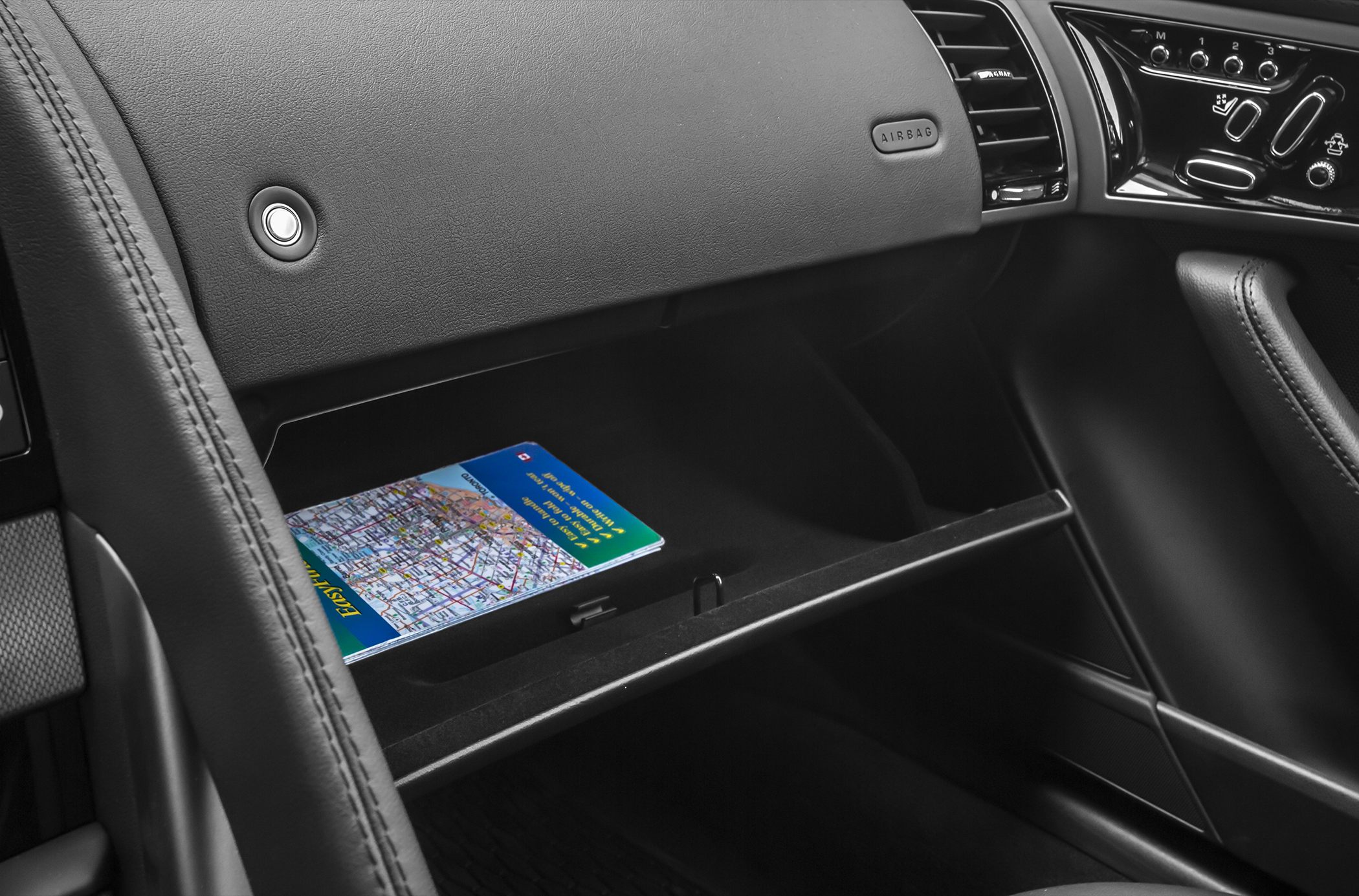 Glovebox interior with map and dashboard controls