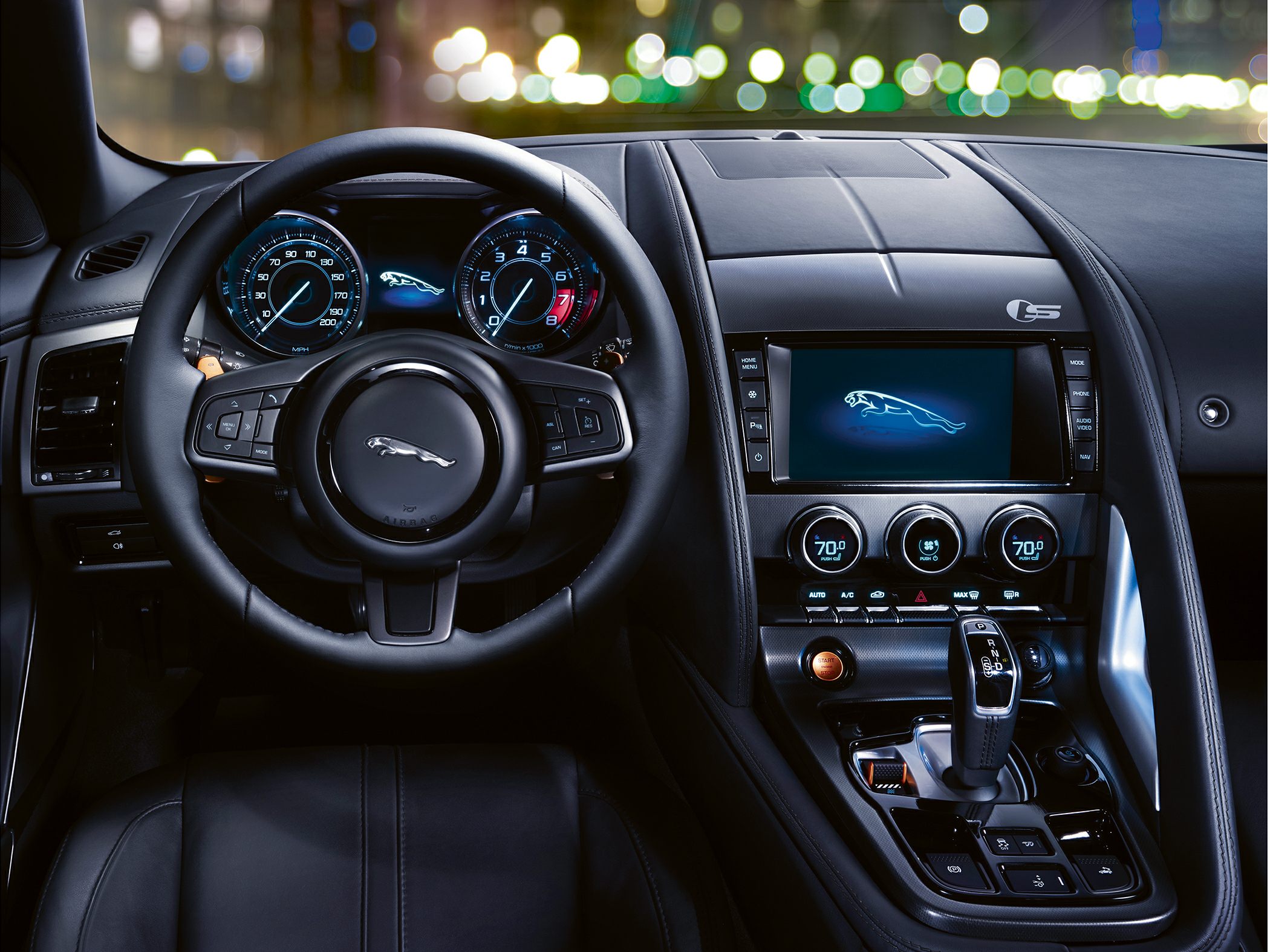 Luxury car interior detail with dashboard, digital displays, and steering wheel.