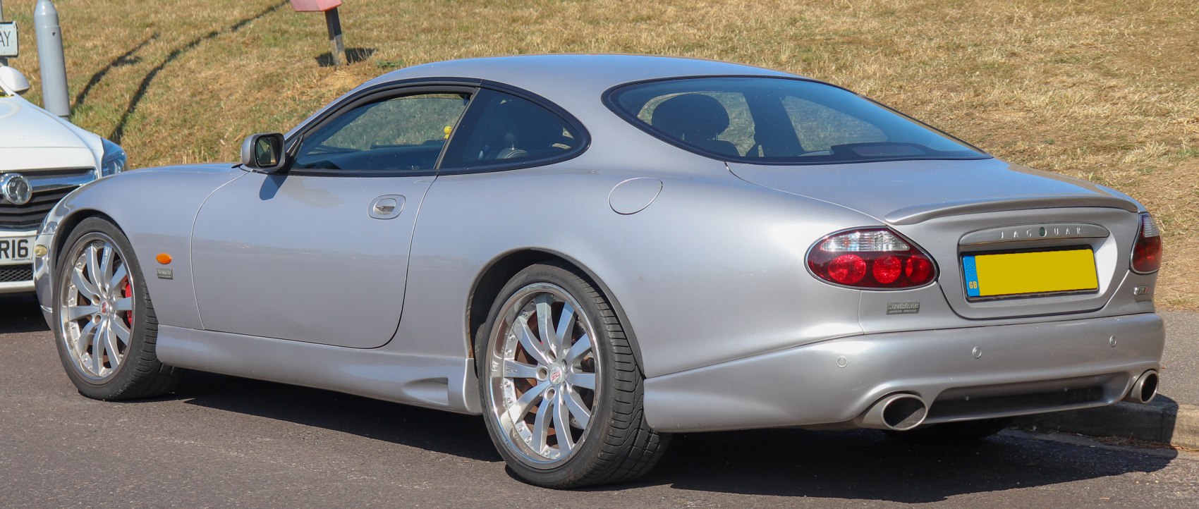 Silver coupe rear side with alloy wheels and distinctive taillights