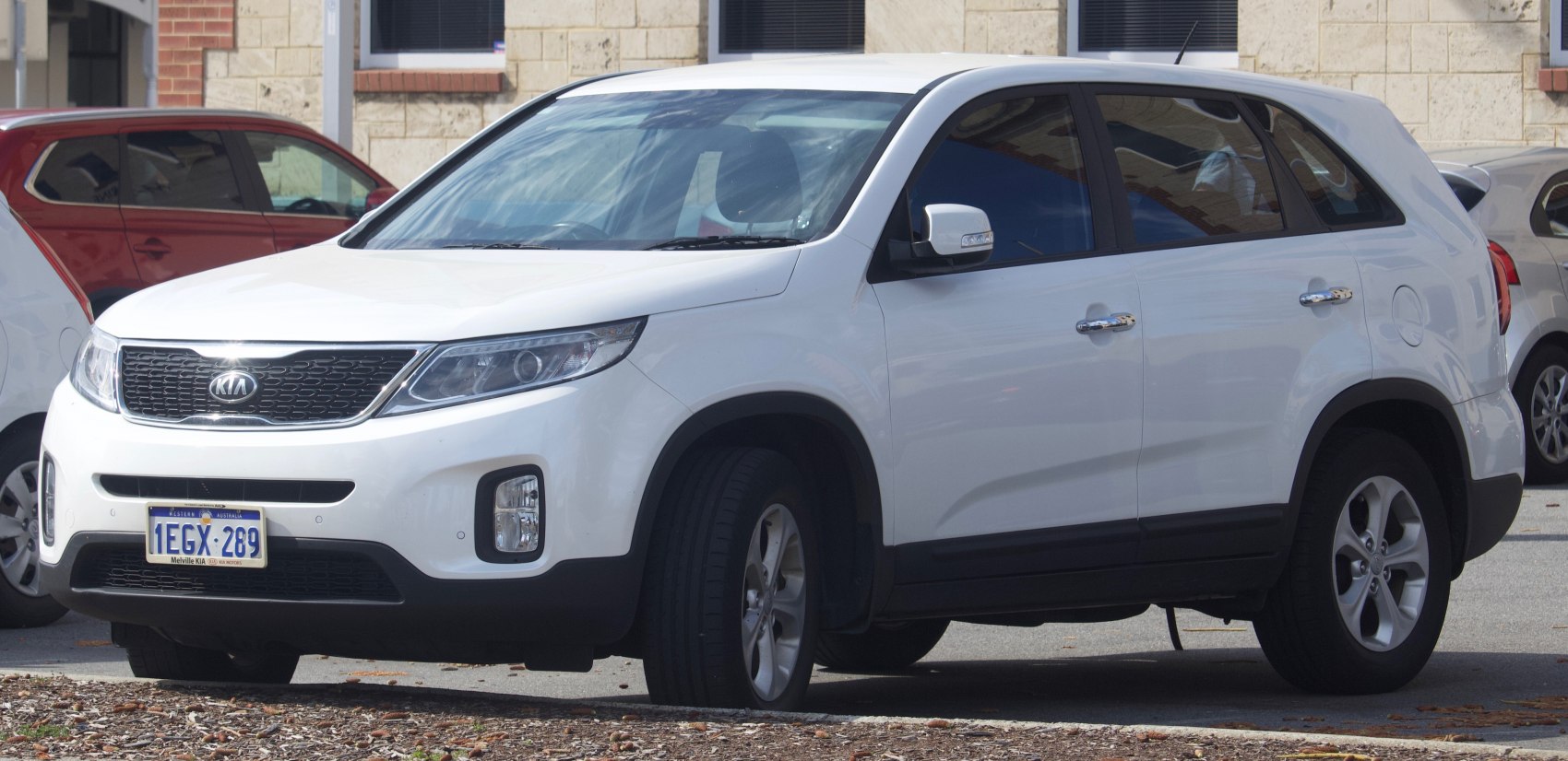 White SUV with front grille and fog lights front side view