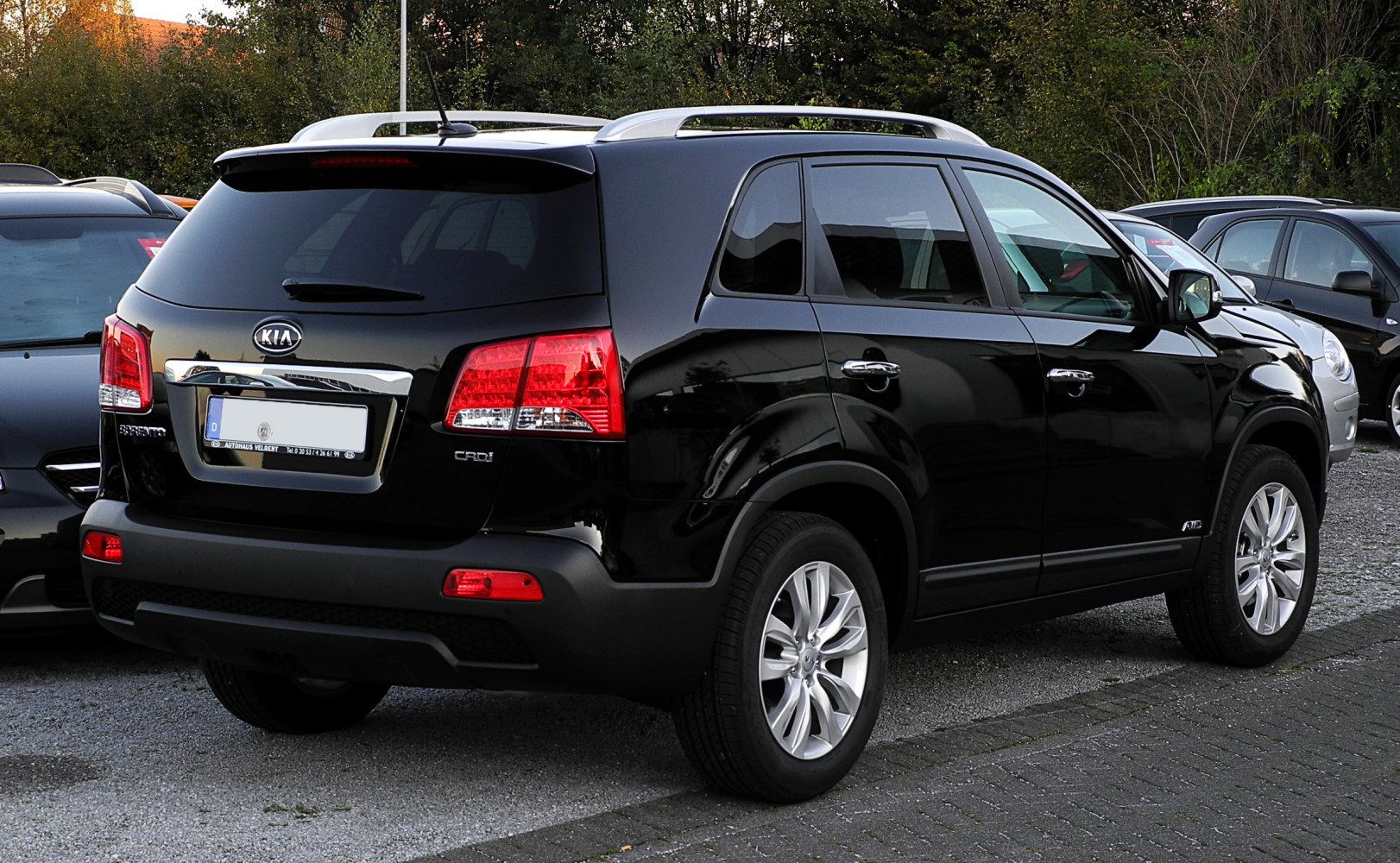 Rear and side view of a black SUV with roof rails and alloy wheels