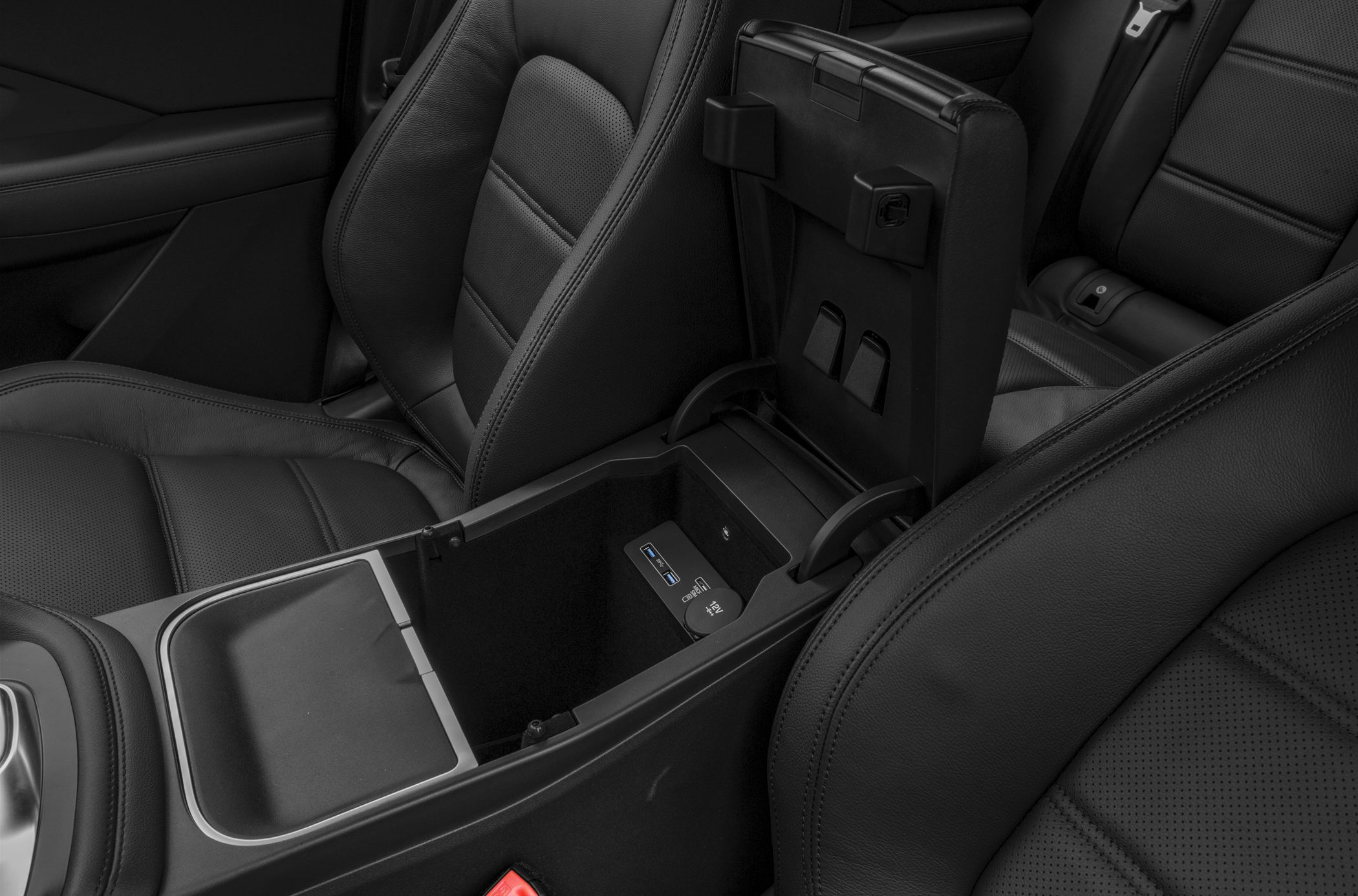 Center console storage compartment with USB ports and black leather seats