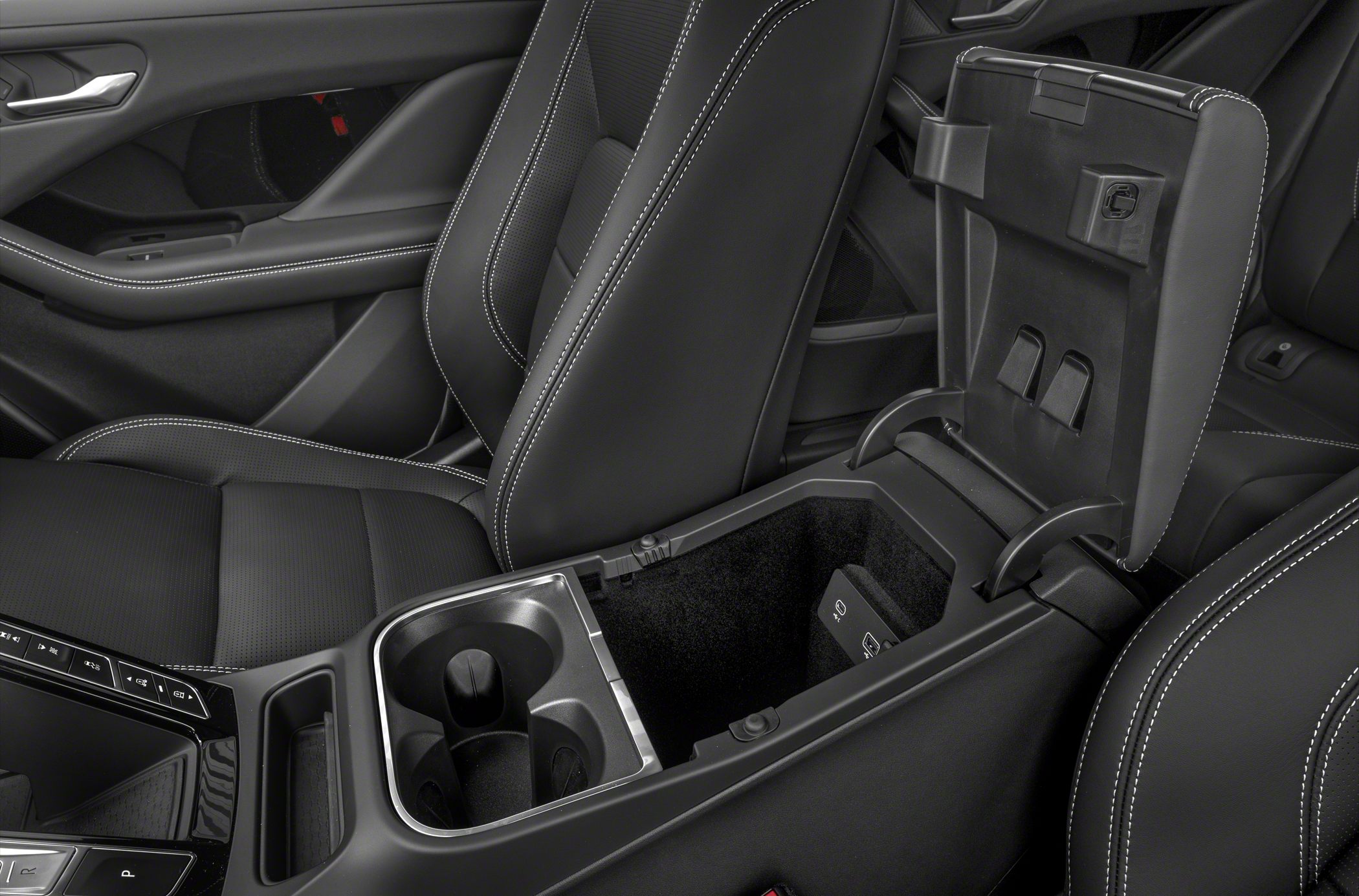 Open center console with cupholders and black leather seats with white stitching