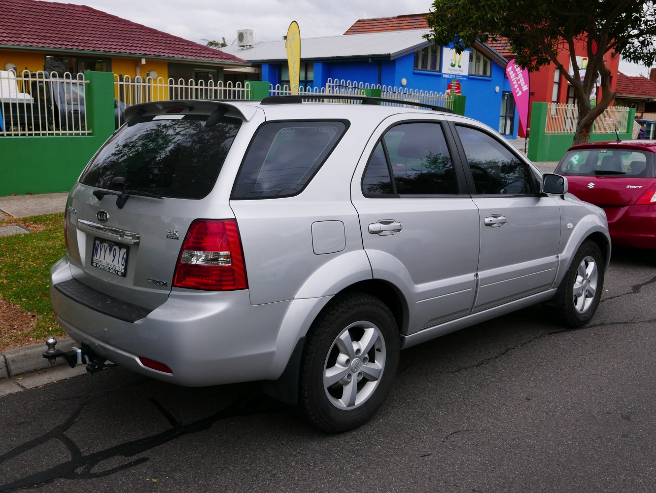 Silver SUV rear side view with tinted windows and roof rails