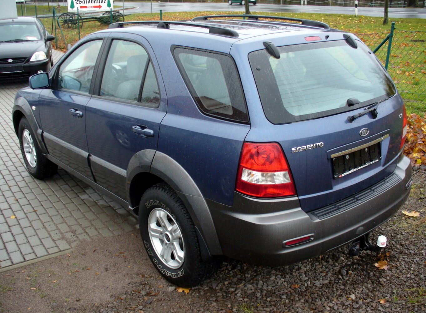 Rear and side view of a blue SUV with rugged design and roof rails