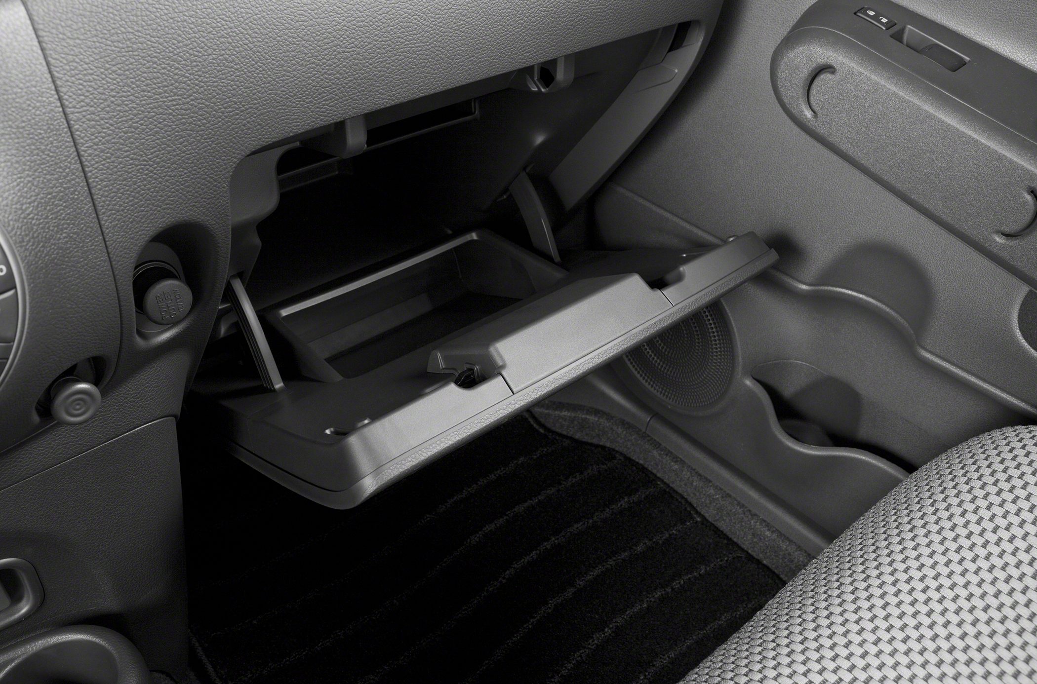 Open glove compartment with visible dashboard and speaker details