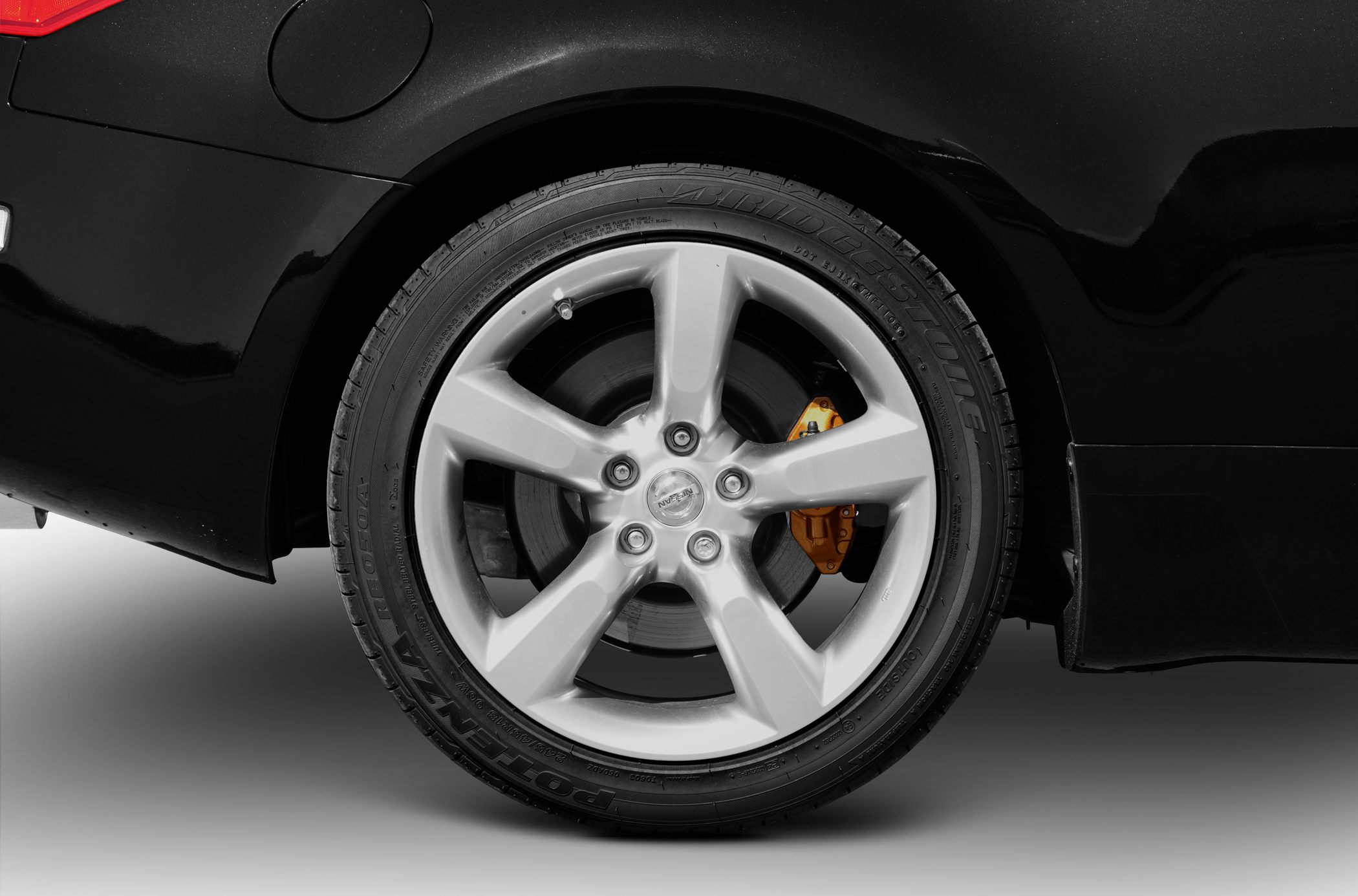 Alloy wheel with brake disc and orange caliper on black body