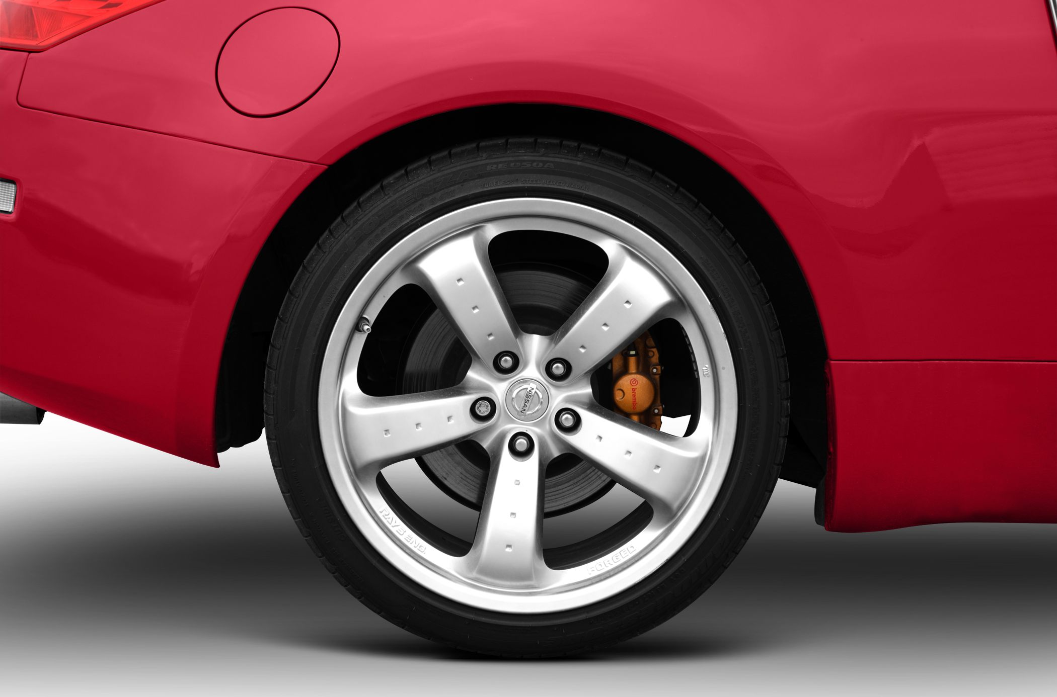 Close-up of alloy rear wheel with Brembo brake caliper on car.