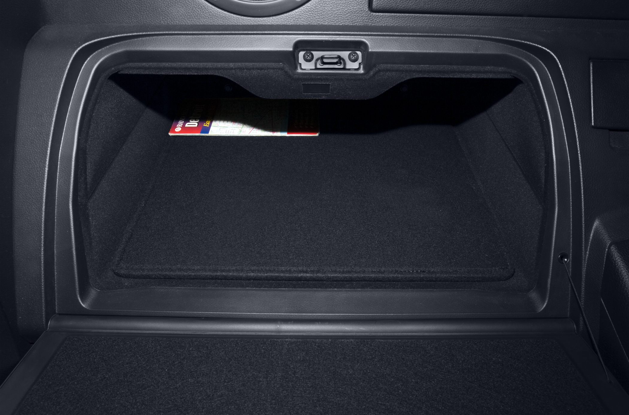 Close-up of Nissan 350Z glove box interior with textured lining and storage space.