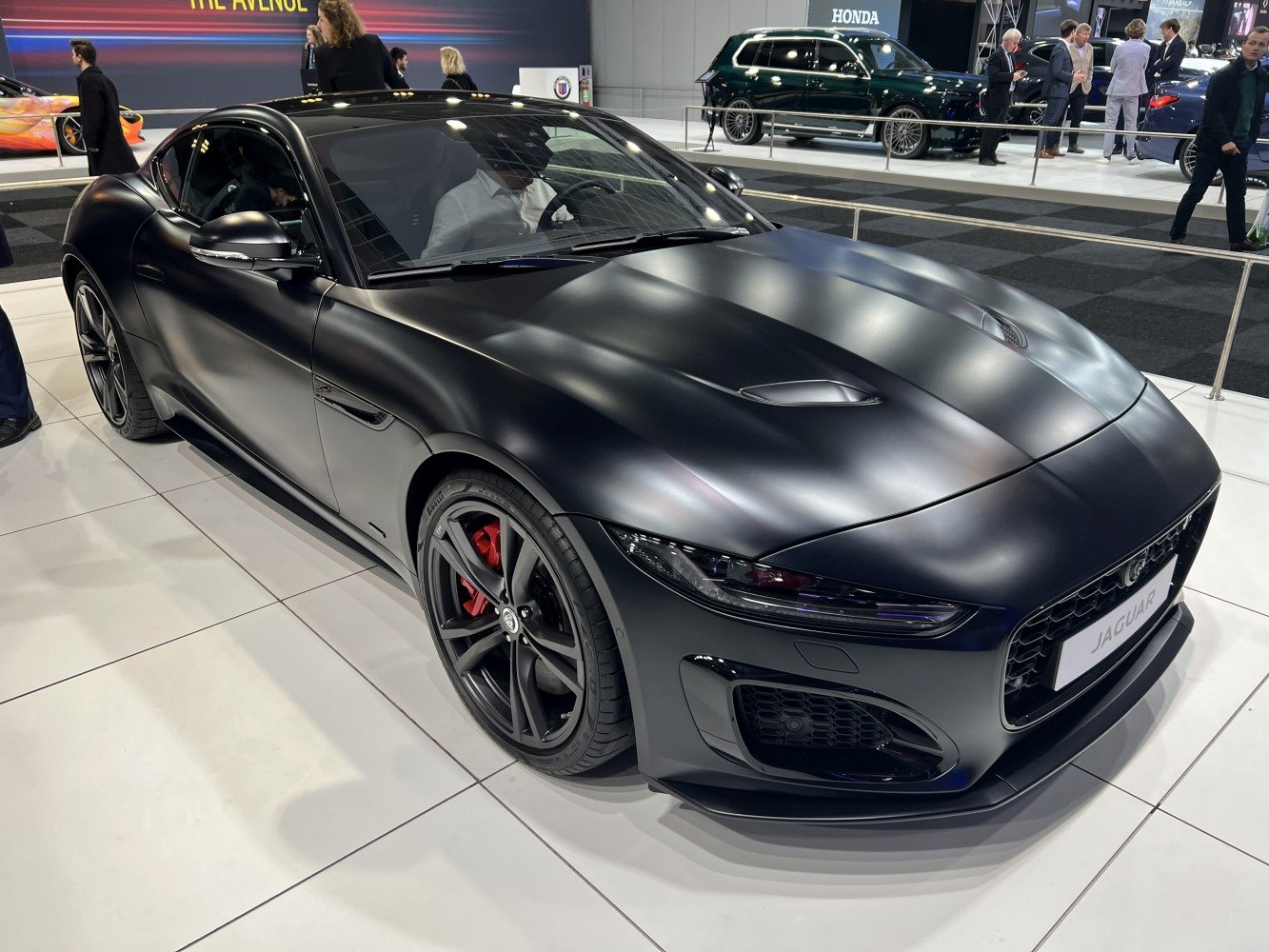 Matte black sports coupe with aggressive front vents and red brake calipers