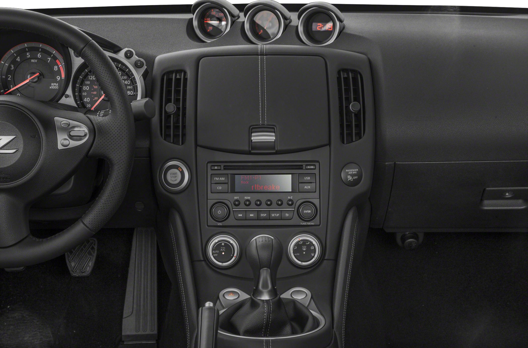 Dashboard and center console with manual gear shifter, gauges, and climate controls