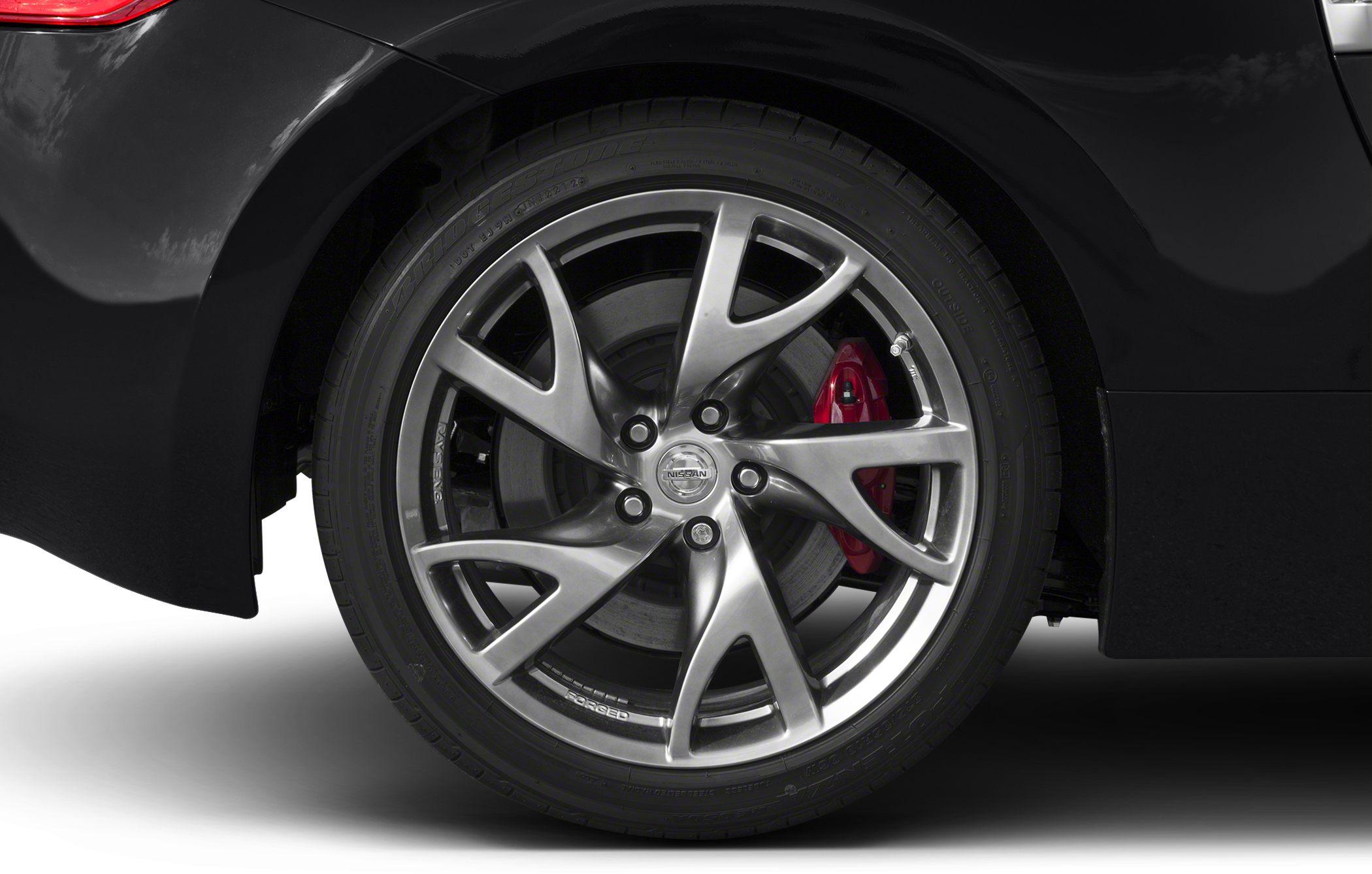 Alloy wheel with red brake caliper on black vehicle
