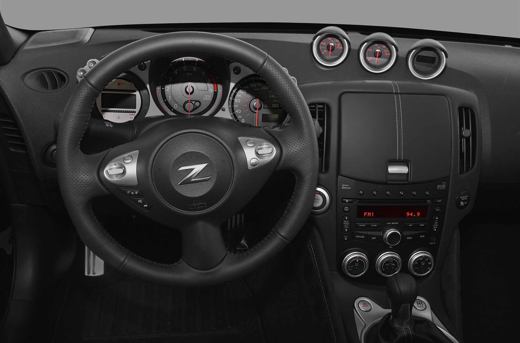 Leather steering wheel, instrument cluster, center console with analog gauges and controls
