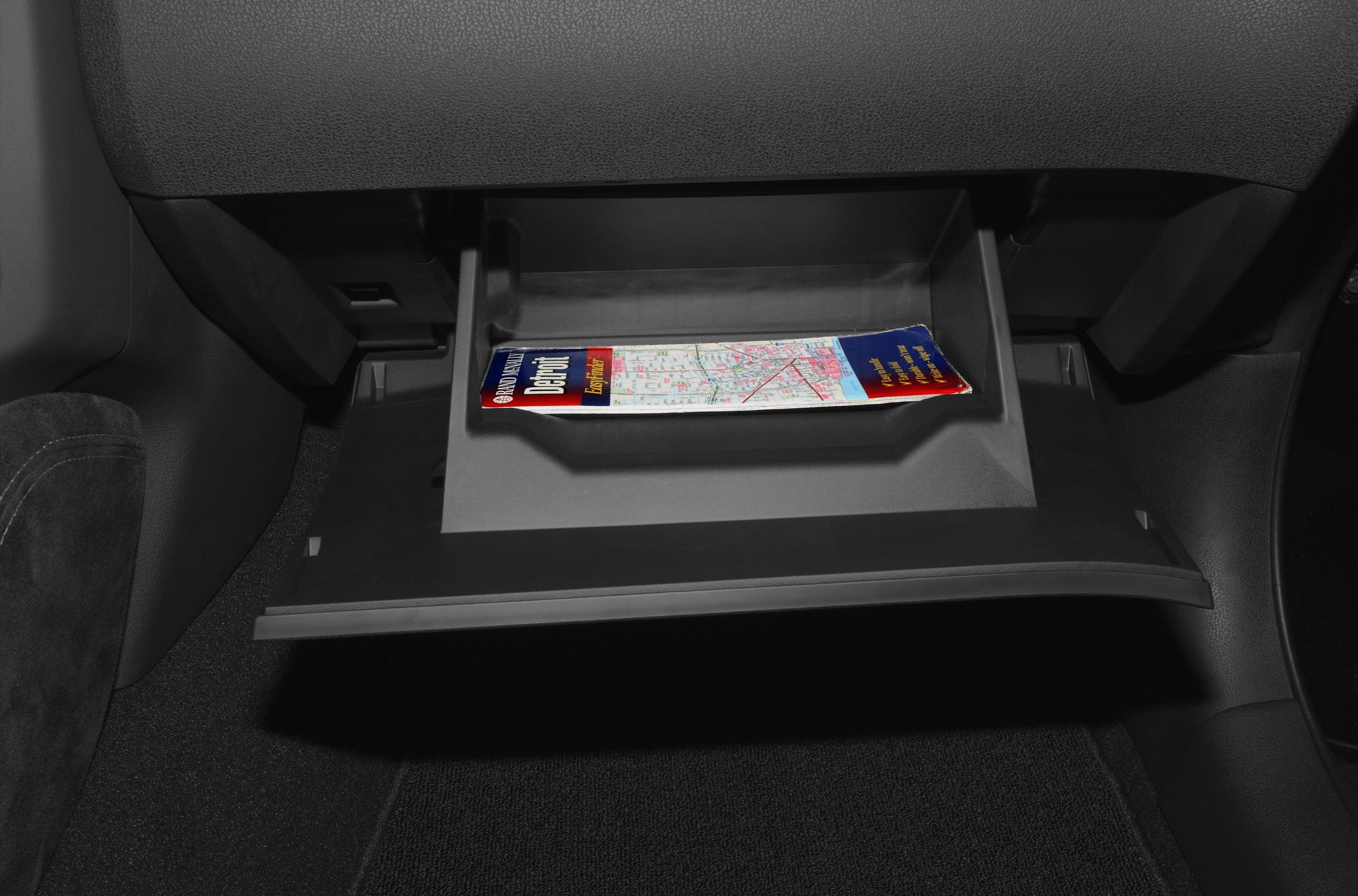 Open glove compartment with map inside car interior
