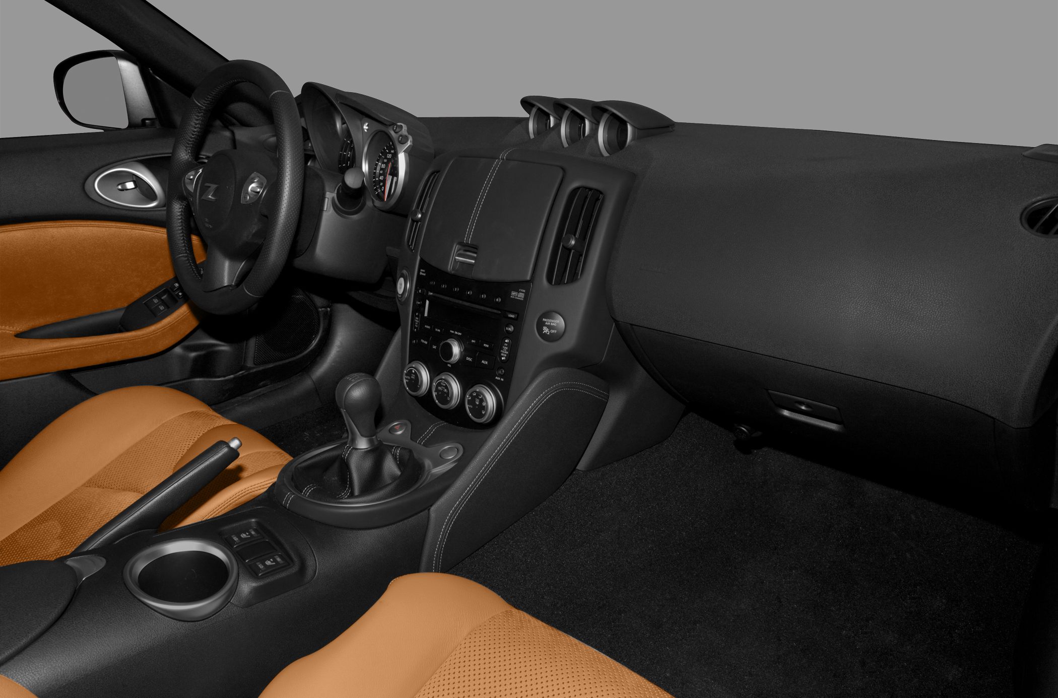 Dashboard, manual gearshift, and tan leather seats in car interior