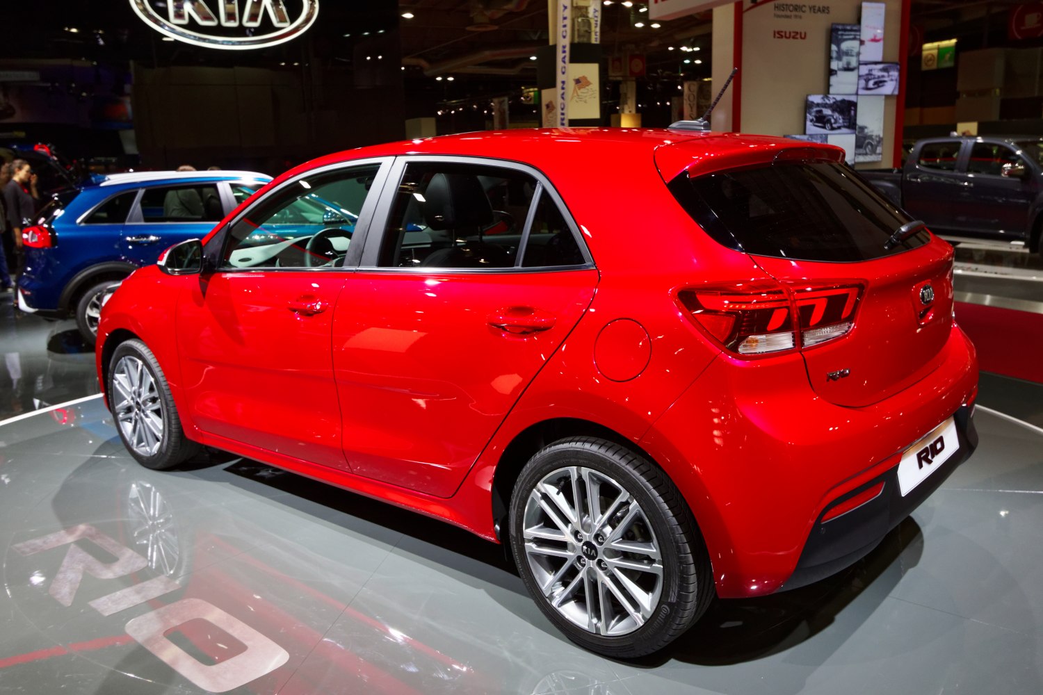 Rear side view of red hatchback with tail lights and alloy wheels
