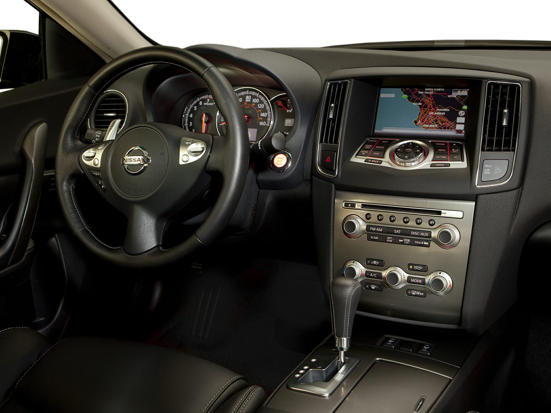 Steering wheel, dashboard gauges, digital navigation screen, and center console controls.