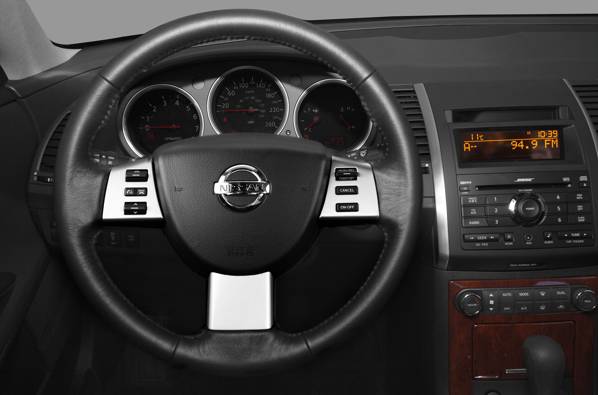 Steering wheel with control buttons and dashboard with gauges and infotainment system