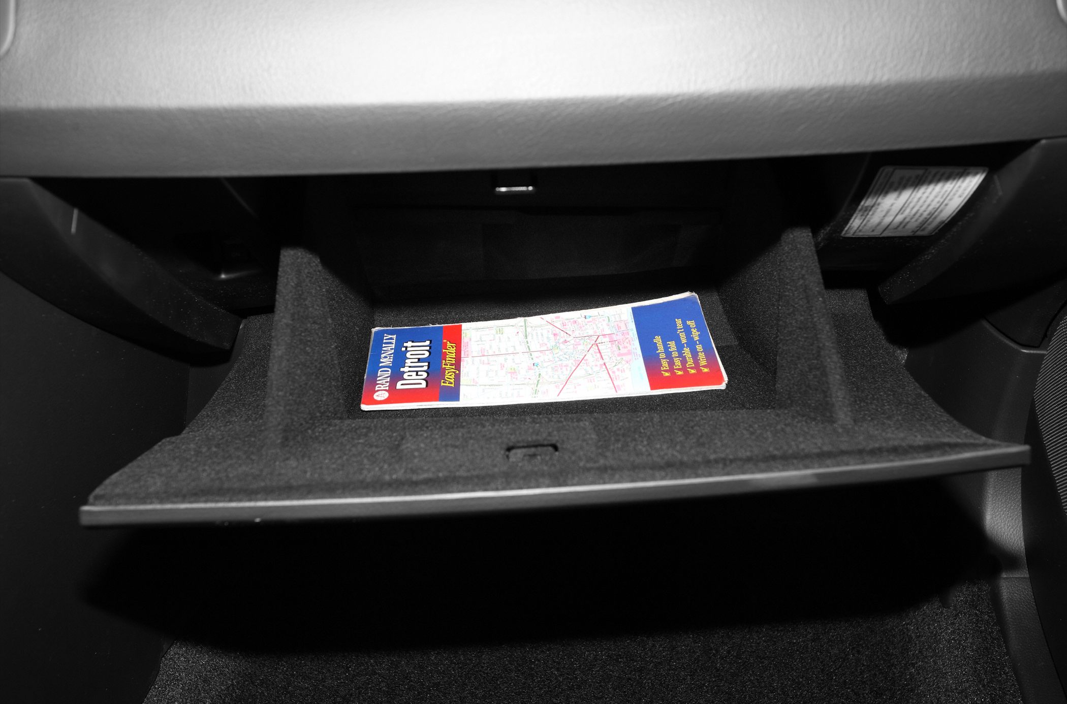 Open glove compartment with paper map inside