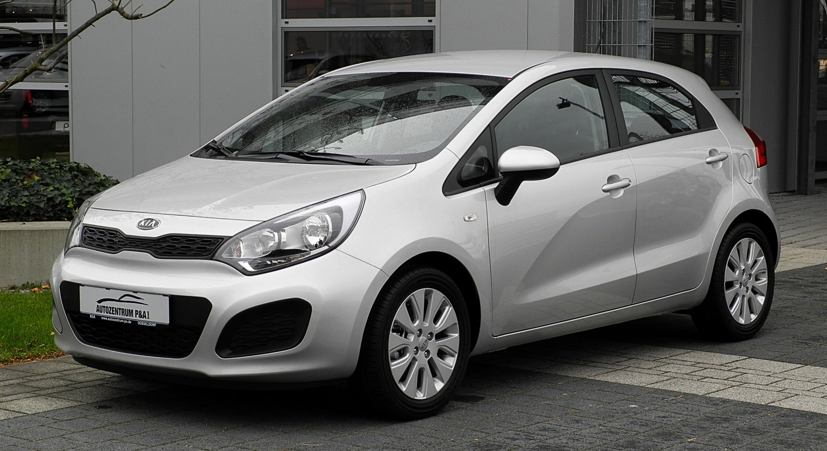 Front side view of a silver compact hatchback with clear headlights and side mirrors