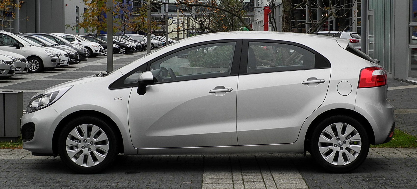 Silver hatchback side view with distinctive door panel curve and alloy wheels.