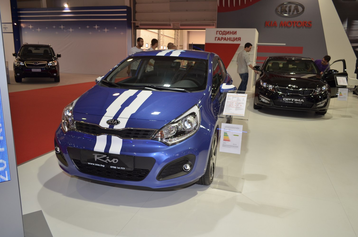 Blue hatchback with dual white racing stripes and prominent headlights