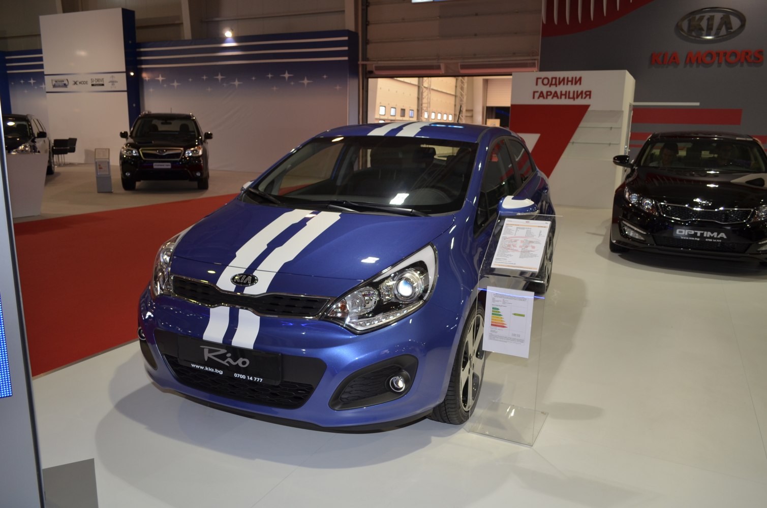 Front view of a blue hatchback with dual white racing stripes.
